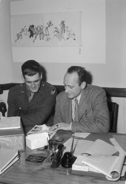 Robert M. Carnes, on the left, advising GI Pvt. Russell Bates of Massachusetts, at the Veterans' Information Headquarters.