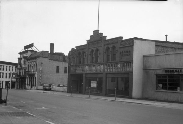 100 block of East Doty Street, showing the Fess Hotel, 119-123; Municipal Parking Station, 115; Kentzler building, 109; and Endres Tiedeman Mobil gas station, 101. This is the location of the proposed Doty Street parking ramp.