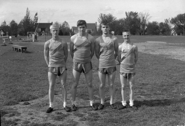 Group portrait of Madison West High School track relay team. Pictured left to right: Tom Yorkson, Bob Mansfield, Greg Blied, and Paul Toltzien.