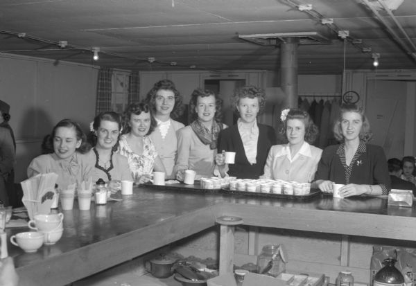 Group portrait of board members of the Red Cross sponsored group "Parlor Tricks". Left to right: Jeanette Youngblood, Dorothy Reis, Betty Johnson, Grace Short, Lorraine Thompson, Pearle Erickson, Olive Faber, and Jo Skalitzky. The "Parlor Tricks" entertain convalescent soldiers at the Army Air Force military hospital at Truax Field.