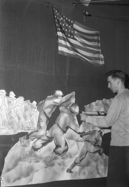 East High School student with an image of U.S. Marines raising the flag on Iwo Jima, which was used for a newly issued 3 cent postage stamp. This stamp is one of a series to commemorate the achievements of the United States Military. This stamp was first placed on sale July 11, 1945.