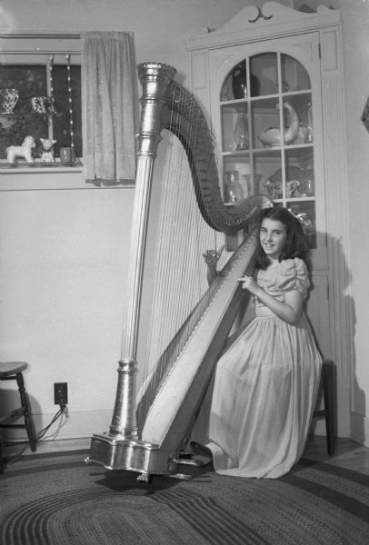 Margaret Rupp Cooper (Mrs. Earl Cooper) playing a harp.  She was a professor of music at the University of Wisconsin and a respected harp teacher.  She was a founding member of the Madison Symphony Orchestra and was well-known for playing in the Christmas pagent in the Wisconsin State Capitol rotunda.
