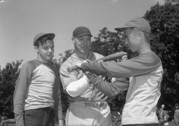 Madison junior baseball leagues director Arthur "Dynamite" Mansfield giving batting tips to Tommy Hunt, left, and Harold Wickert, right, two of the 588 youth in the summer program.