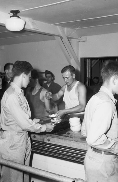 An Army cook dishes out Pfc. Howard A. Endres's last meal at Camp Grant, Rockford, Illinois, home on furlough after Victory in Europe Day. After his furlough, Endres was sent back to active duty in the Pacific Theater until the end of the war a couple of months later.