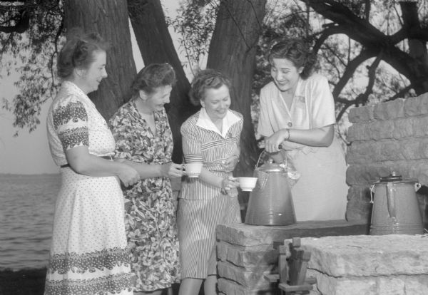 Serving at the Who's New Club picnic, Mrs. Lawrence (Violet) Kingsbury, Mrs. Cyril F. (Eylene) Sherman, Mrs. Joseph (Enid) Tripp, and Mrs. William B. (Catherine) Gedko.