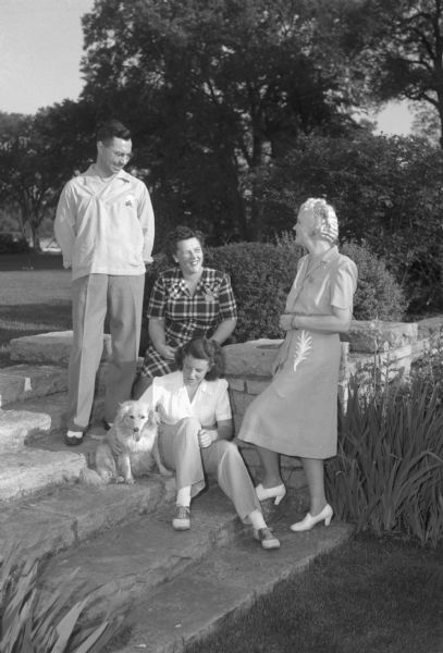 At the Who's New Club picnic in the garden of Lieut. Governor Oscar Rennebohm. Mrs. Oscar (Mary) Rennebohm is shown with guests, Mr. and Mrs. William (Helen) Luske, and Carol Rennebohm and her dog, Sandy.