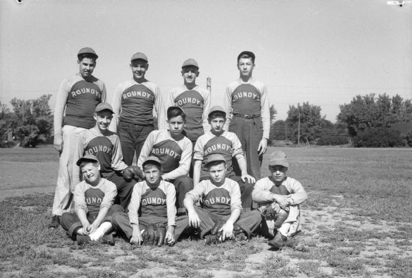 Group portrait of eleven members of Roundy's midget league baseball team.