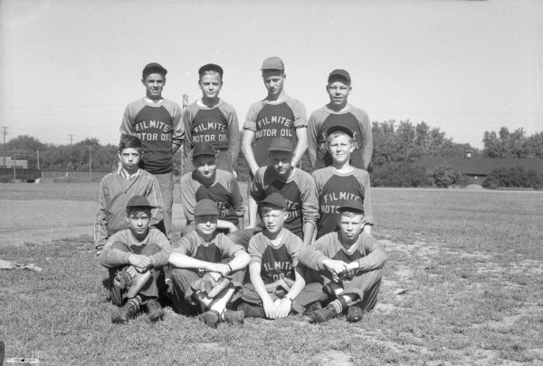 Group portrait of twelve members of the Filmite Motor Oil baseball team.
