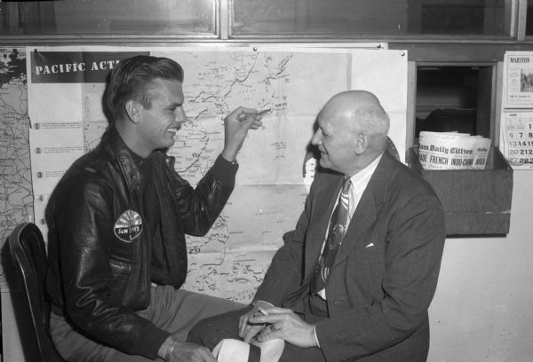 First Lieut. Robert V. Merklein is showing his father, O.F. Merklein, the location of Yokohama, where he downed his first Japanese plane.