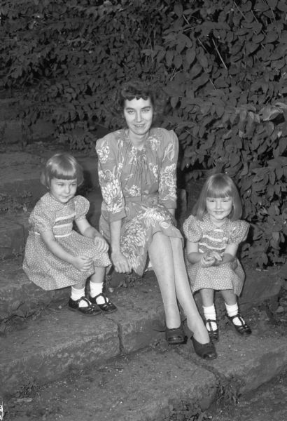 Group portrait of Mrs. Fred (Marguerite Jenks) Snyder and her daughters, Ruth and Peggy. Mrs. Snyder and her daughters are guests of her parents and grandfather, Mr. and Mrs. Frank Jenks and Prof. Daniel W. Mead.