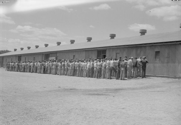 German prisoners of war line up for inspection outside their barracks before going to work at a local cannery.