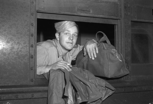 Private Lawrence Mueller, Madison, arriving on a train at Camp McCoy for a short furlough before re-deployment to the Pacific.