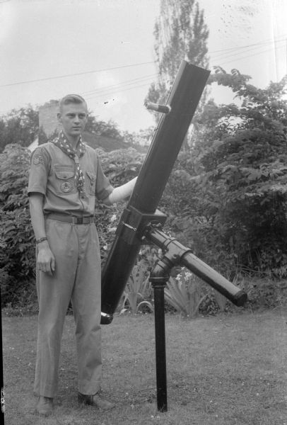 Robert Burkhalter, a life Boy Scout member of Troop 5, standing next to the telescope he built and mounted in his backyard, 105 Cambridge Road, Shorewood Hills.