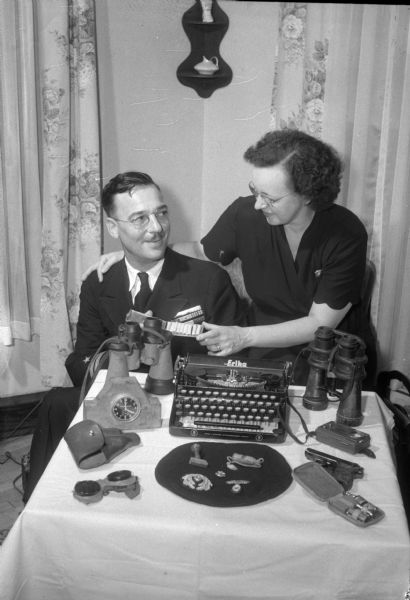 Lieut. Albert L. David showing his wife, Georgia, the souvenirs he brought from the capture of the German U-505 underseas craft. He stood two days and nights steering the craft not knowing when it might sink.