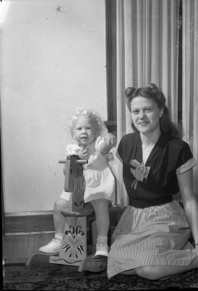 Mrs. Paul (Betty) Jensen and her daughter Karen (on rocking horse) are living with her husband's parents, Mr. and Mrs. Paul Jensen, while her husband is in service.