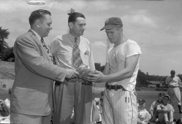 Charles "Chick" Lowe receiving an award from Leonard T. "Dutch" Midland, president of the Wisconsin-Felton Sporting Goods Company, and Eddie Krajnik, Philadelphia Phillies scout and director of the tryout camp held at Breese Stevens Field. He was an Army infantryman home on leave and rated the most improved player at the camp.