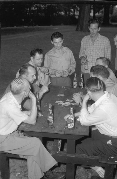 Male employees of RMR playing cards at a company picnic.