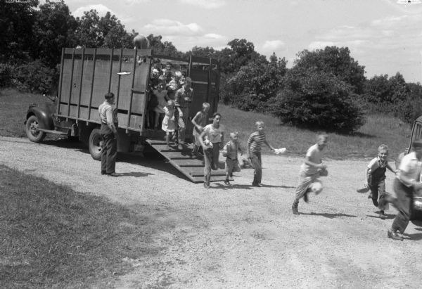 Children leaving the truck hired by the Red Cross Chapter of Mt. Horeb to drive them to a swimming class at the Bluemounds pool.