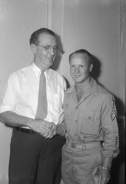 "Roundy" Coughlin, <i>Wisconsin State Journal</i> columnist, visiting with an old friend, Sgt. "Red" White, 32nd Division veteran, who returned to Madison from the Pacific. More than half of the veteran's 40 months overseas were spent in combat areas.