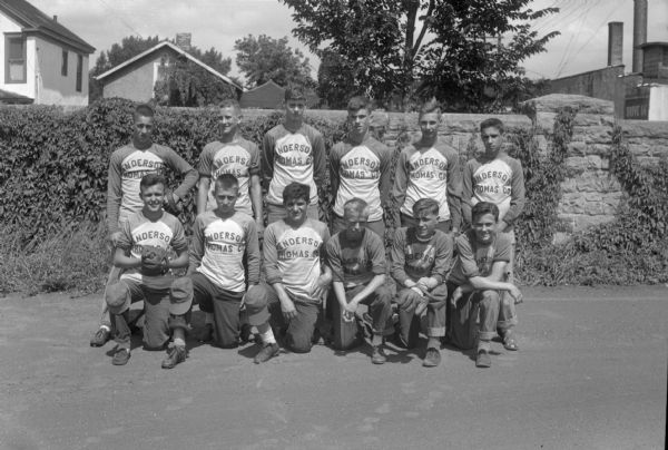 Group portrait of twelve baseball players in uniform, members of the Anderson-Thomas Co. baseball team.