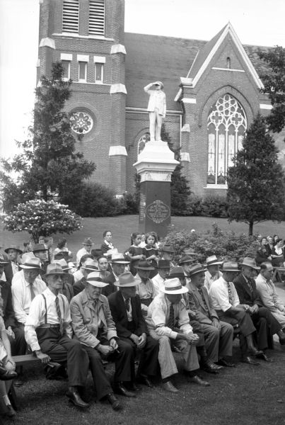 Part of the crowd celebrating the New Glarus Centennial. In the background is a monument in memory of the first settlers of the Swiss colony of New Glarus and the Swiss Evangelical and Reformed Church.