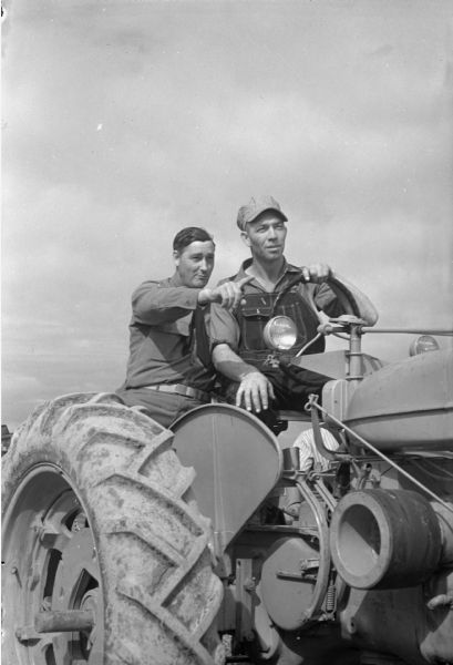 Perry Carroll, Baraboo, and Carl Ribbke, on a tractor at a terrace plowing demonstration on the Ribbke farm near Ableman.