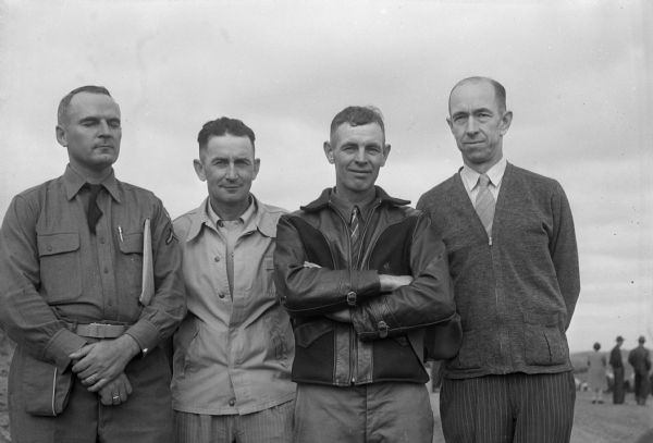 Group portrait of the four men in charge of the terrace plowing demonstration and conservation field day on the Carl Ribbke farm near Ableman. From left are: Dick Stauffacher, district soil conservationist; Roy Bailey, Sauk County Agricultural Adjustment Administration; Herbert R. Meyer, chairman of the Sauk County soil conservation district; and Dave Williams, Sauk County agricultural agent.