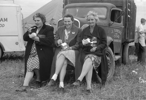 Three farm wives are  taking a break at the terrace plowing demonstration and conservation field day on the Carl Ribbke farm near Ableman. From left are Mrs. Archie Prouty, Hillpoint; Mrs. Vreneman and Mrs. Jesse Breneman, both of Cazenovia.