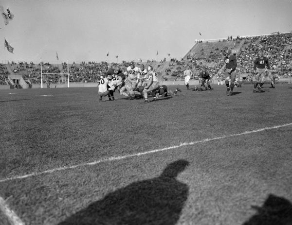Wisconsin - Purdue Football Game at Camp Randall stadium, showing Wisconsin player, Jerry Thompson, number 44, being stopped by Purdue players Bob DeMoss, number 50, Patrick O'Brien, number 82, Joseph Kodba, number 36. Wisconsin lost 13 to 7.