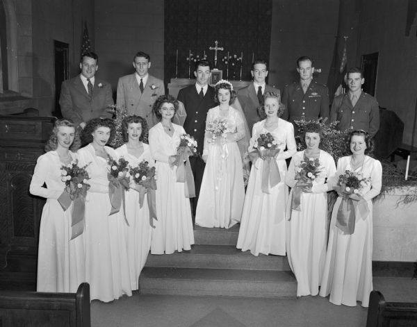 Ann Morris and James Fitzsimmons wedding party of seven bridesmaids and five groomsmen standing in front of the church altar of St. Andrews Episcopal Church.