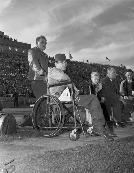 Man in a wheelchair on the sidelines of the Wisconsin-Illinois football game at Camp Randall Stadium. He is possibly Robert Butts, the founder of the annual Dad's Day game. He was celebrating the 25th Dad's Day with his son, Robert, Jr., a freshman on the University of Wisconsin-Madison team.