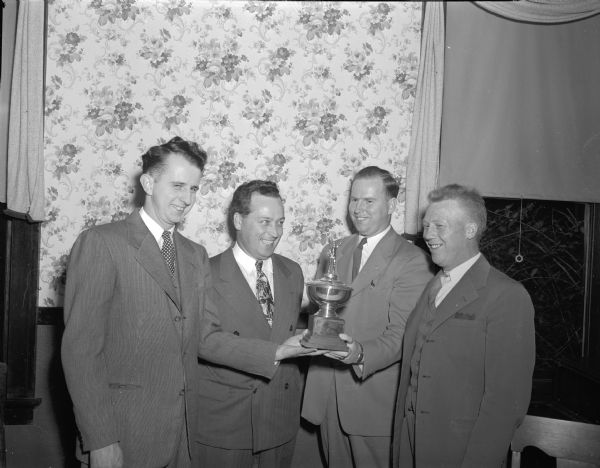 Roy Sarbacker, Joe Stanley, Walt Nitum, and Delmar Offerdahl with the trophy of the championship baseball Home Talent League team.