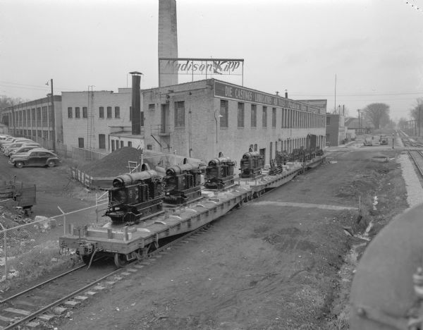Madison-Kipp Corporation, 201 Waubesa Street, beside the Chicago, Milwaukee, St. Paul and Pacific railroad tracks.  Shown are three loaded flatcars on a siding next to the building.