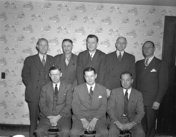 Group portrait of eight men in business suits at the Nakoma Country Club.