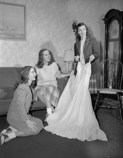 Shown left to right are: Judith Tormey, Florence Crowley, and holding a formal dress, Kathleen Kellogg. They are students at Rosary College.