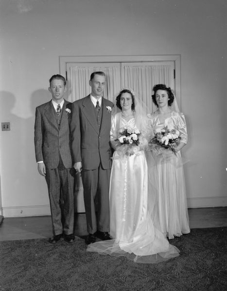 Martha M. Goodlet and Robert P. Hanson wedding party in University Methodist Church Parlor.  Left to right: Wayne Hanson, best man, Robert P. Hanson, bridegroom, Martha M. Goodlet, bride, and Irene Mees, matron of honor.