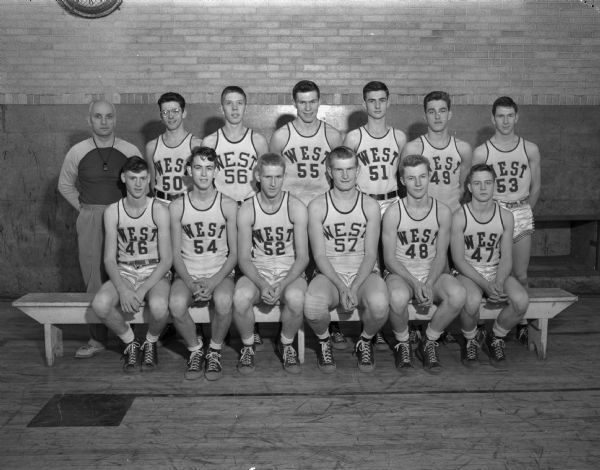 Group portrait of Madison West High School boy's basketball squad in uniform with the coach.