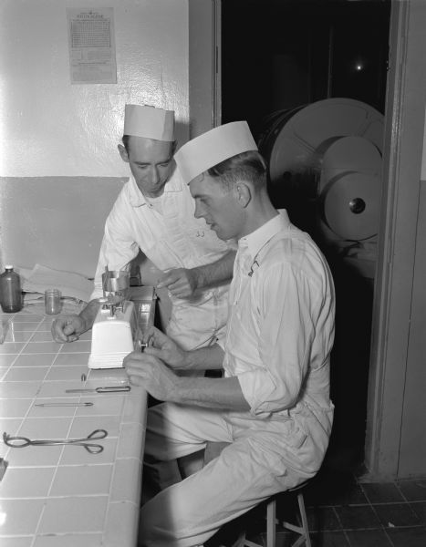 Two men performing a test in a laboratory at the Madison Dairy, 1018 East Washington Avenue.