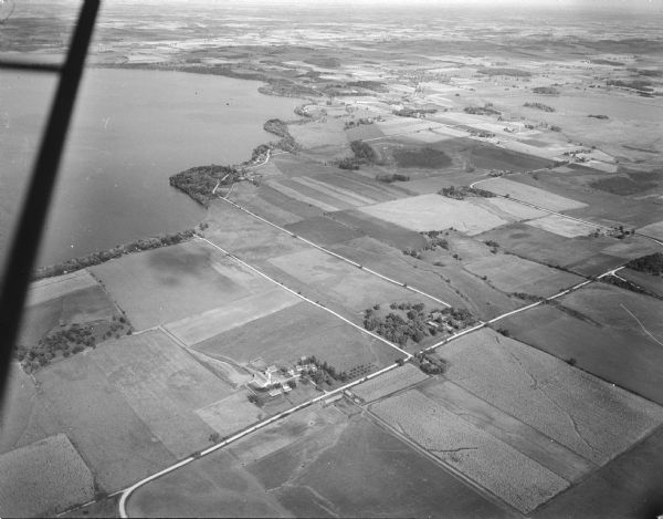 Aerial view of rural lake shoreline showing farm and settlements.