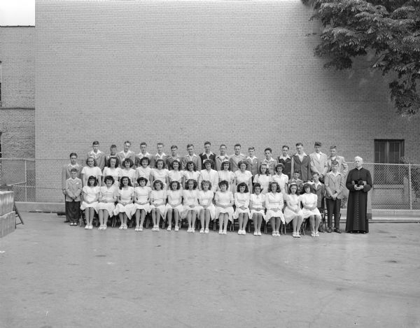 Group portrait of the 8th grade graduation class, St. Raphael's Catholic School, 216 West Main Street. Pictured are the forty-seven graduates and a priest.