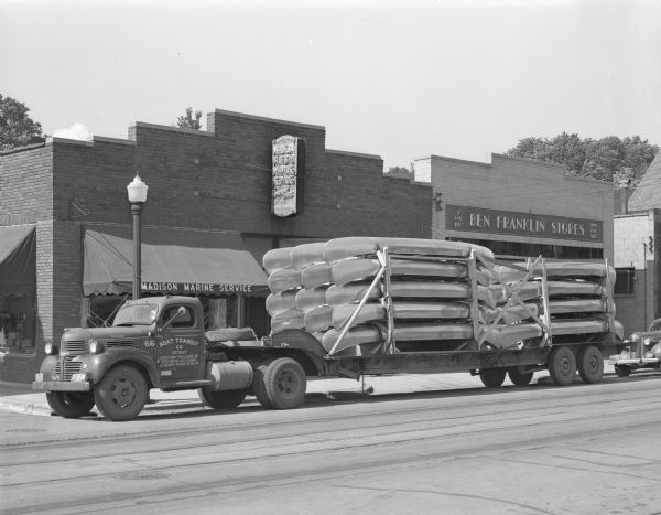 A truckload of twenty-eight aluminum canoes in front of Madison Marine Service, 2102 Atwood Avenue. They were transported from Long Island, New York. The Ben Franklin store can be seen next door.