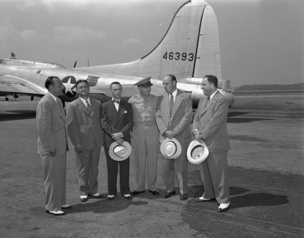 Lieutenant General Eaker at the Madison airport in front of a B-17 bomber. He is shown with State Representative K. Henry (R-Jefferson) and welcoming committee members Bill Hoard, Allen Jones, Howard Carmany and Bud Baudette.