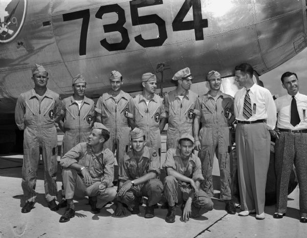 The original crew of "Dave's Dream," the B-29 airplane which dropped the first atomic bomb on Bikini Island, in front of the plane at Truax Field during a homecoming tour. Last person on the right in military uniform is pilot Major Woodrow Swancutt, Wisconsin Rapids native and former University of Wisconsin student. Last person on the right (in civilian clothes) is Dick Johnson, former college roommate of Swancutt and chairman of the Waupaca reception committee, who will take the crew to that city's veterans' homecoming celebration.