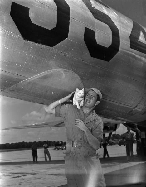Pfc. Charles F. Moore with cat "Kwajie" who was the mascot of the B-29 airplane "Dave's Dream" and who made the trip over Bikini when the plane dropped the atomic bomb during the first test on July 1, 1946.