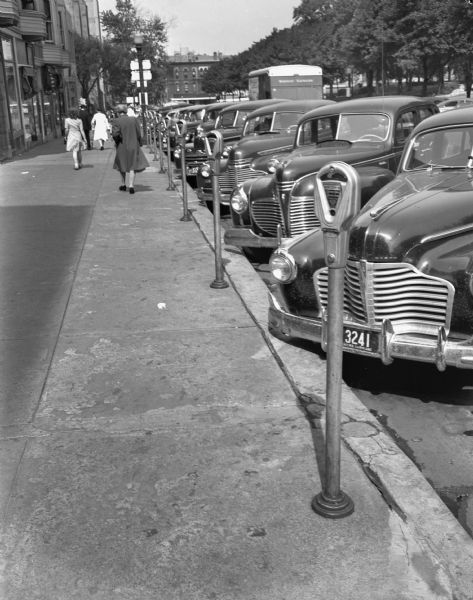 Street scene showing cars parked at parking meters on South Carroll Street on Capitol Square.