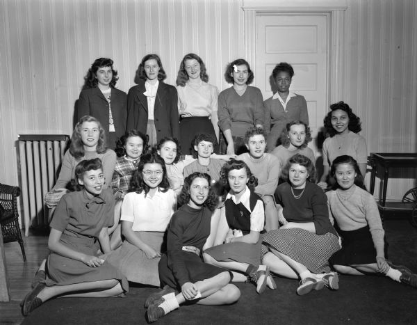 Group portrait of eighteen women who are resident-members of Groves Women's Cooperative House, 1104 West Johnson Street, inter-racial home for University of Wisconsin-Madison students. The cooperative is named for Professor Harold M. Groves, professor of economics at the university.