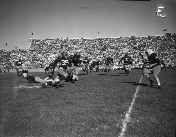 Action photograph of Fullback Earl Maves (No. 35) running for a touchdown during the University of Wisconsin-Madison vs. Marquette football game.