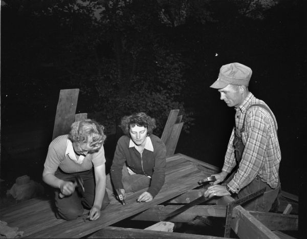 Ms. Alvin (Eleanor) Moore, 4219 Doncaster Drive, and her brother and sister-in-law, Mr. and Mrs. Wesley Bakken of Mt. Horeb, installing the roof at the Moore home.