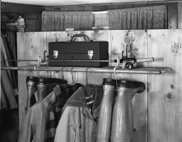 Fishing tackle box and fishing rod rack located on a closet shelf, taken for R.L. Kulzick Advertising Company, 409 East Washington Avenue.