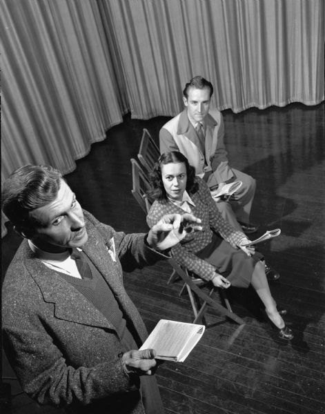 Two men and one woman rehearsing a play.